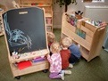 school children playing with an art easel