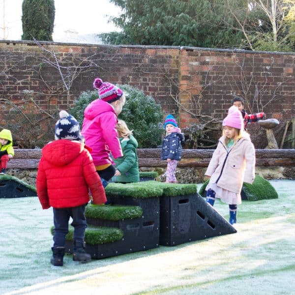 nursery kids playing in snow on step and ramp blocks
