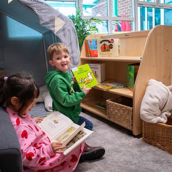 nursery boy showing the camera a book by a Millhouse Bookcase