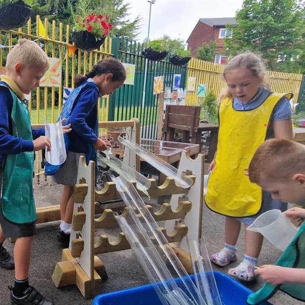 primary school students playing with water wall