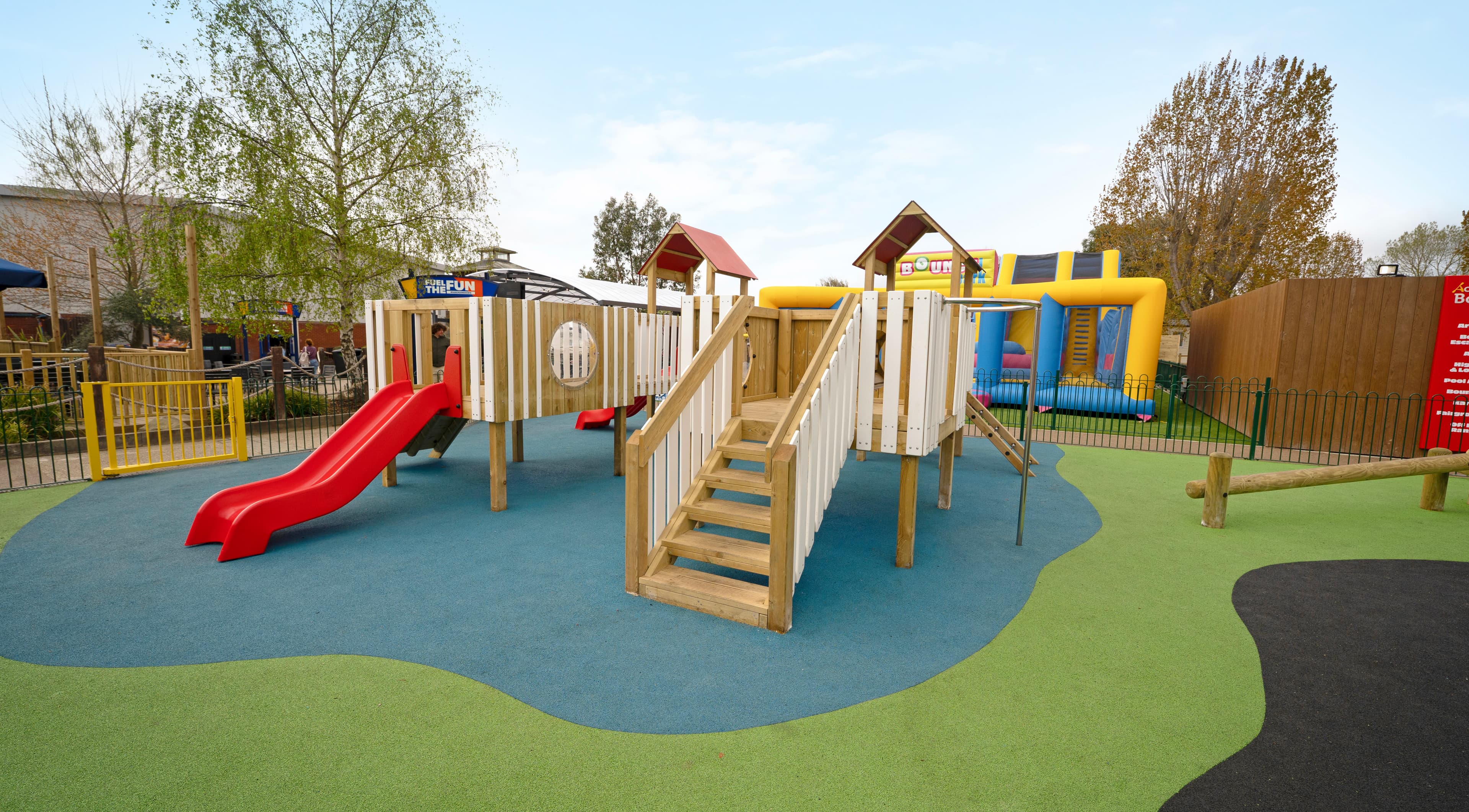 multi-use-games-area with artificial grass and fencing alongside a clmbing frame, play tower, outdoor classroom and tyre trim trail