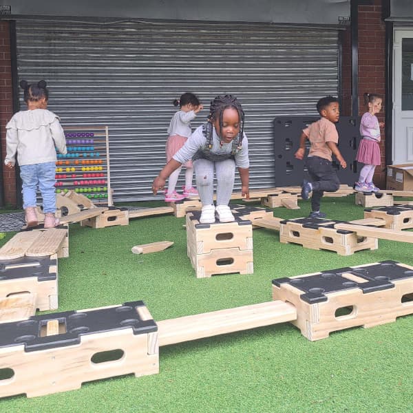 child preparing to jump from one block to another on Play Builder set