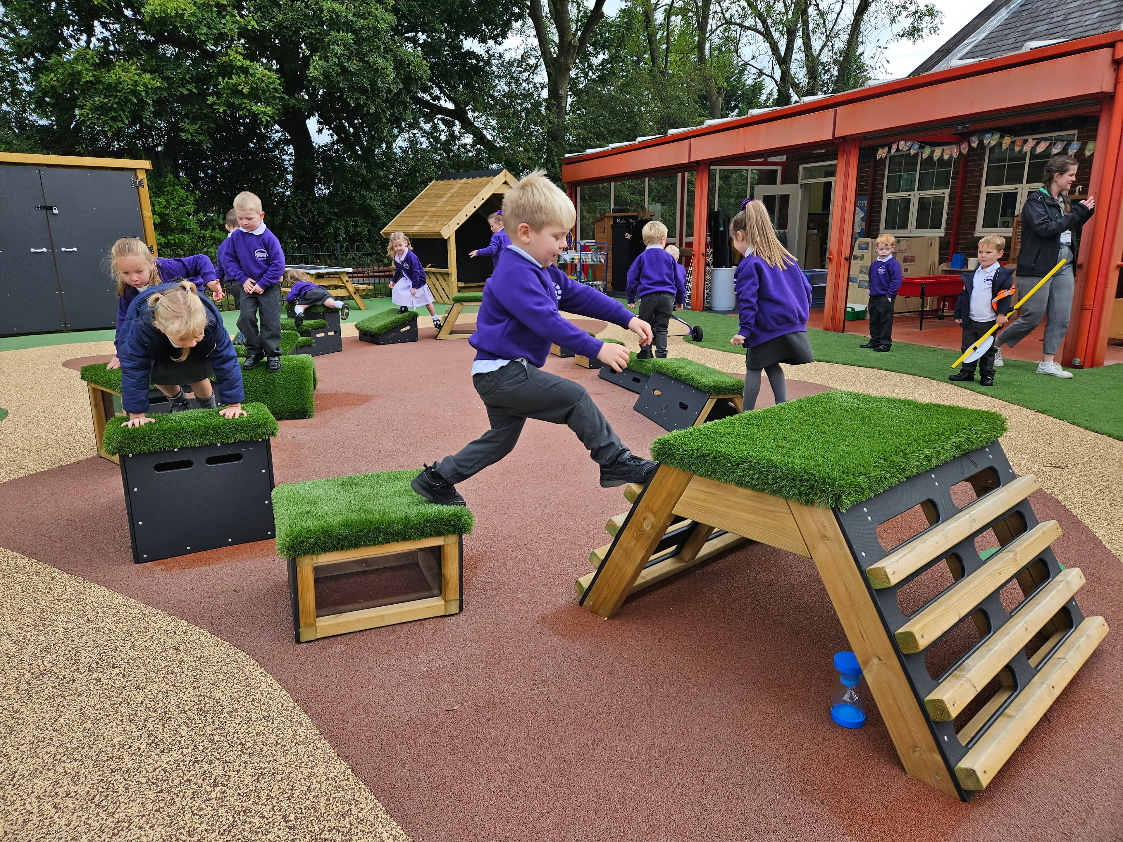 Primary School children playing out outside on grass-topped Get Set, Go! Blocks - Cheviot Set.