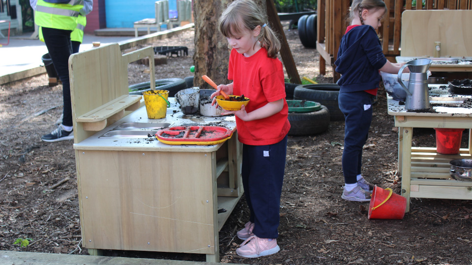 Child playing with mud kitchen