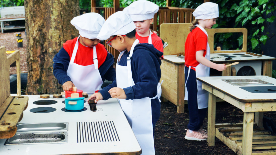 Children working at mud kitchen