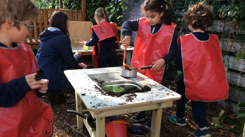 Students playing with mud kitchen island