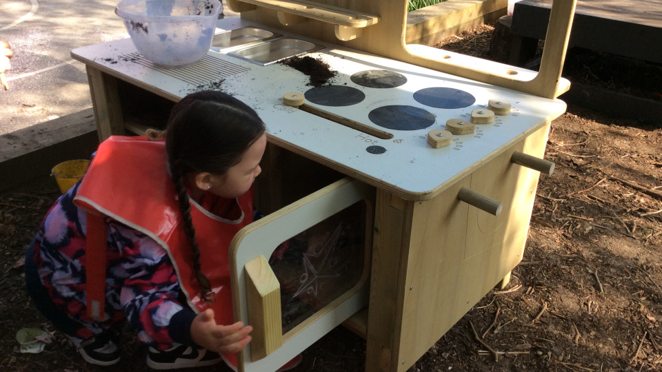 Student working with mud oven