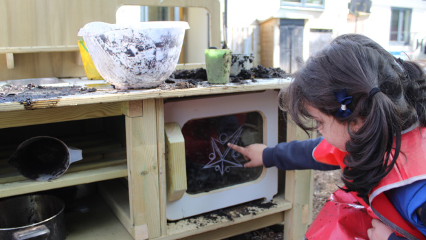 Child playing with mud oven