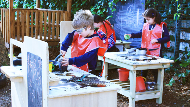 Child working on mud kitchen