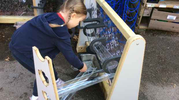 child playing with water wall